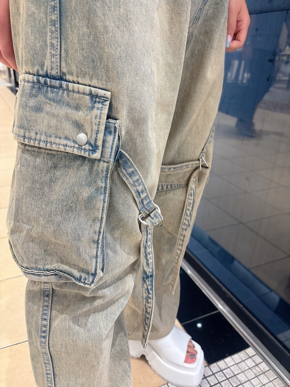 ブルー系のデニムパンツ、ブルー系のキャミソール、ホワイト系のサンダルを着用したレディースの夏コーディネートの8枚目の写真