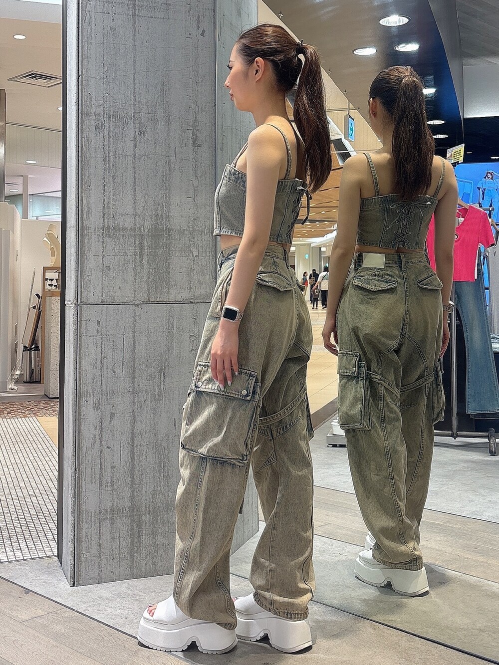 ブルー系のデニムパンツ、ブルー系のキャミソール、ホワイト系のサンダルを着用したレディースの夏コーディネートの3枚目の写真