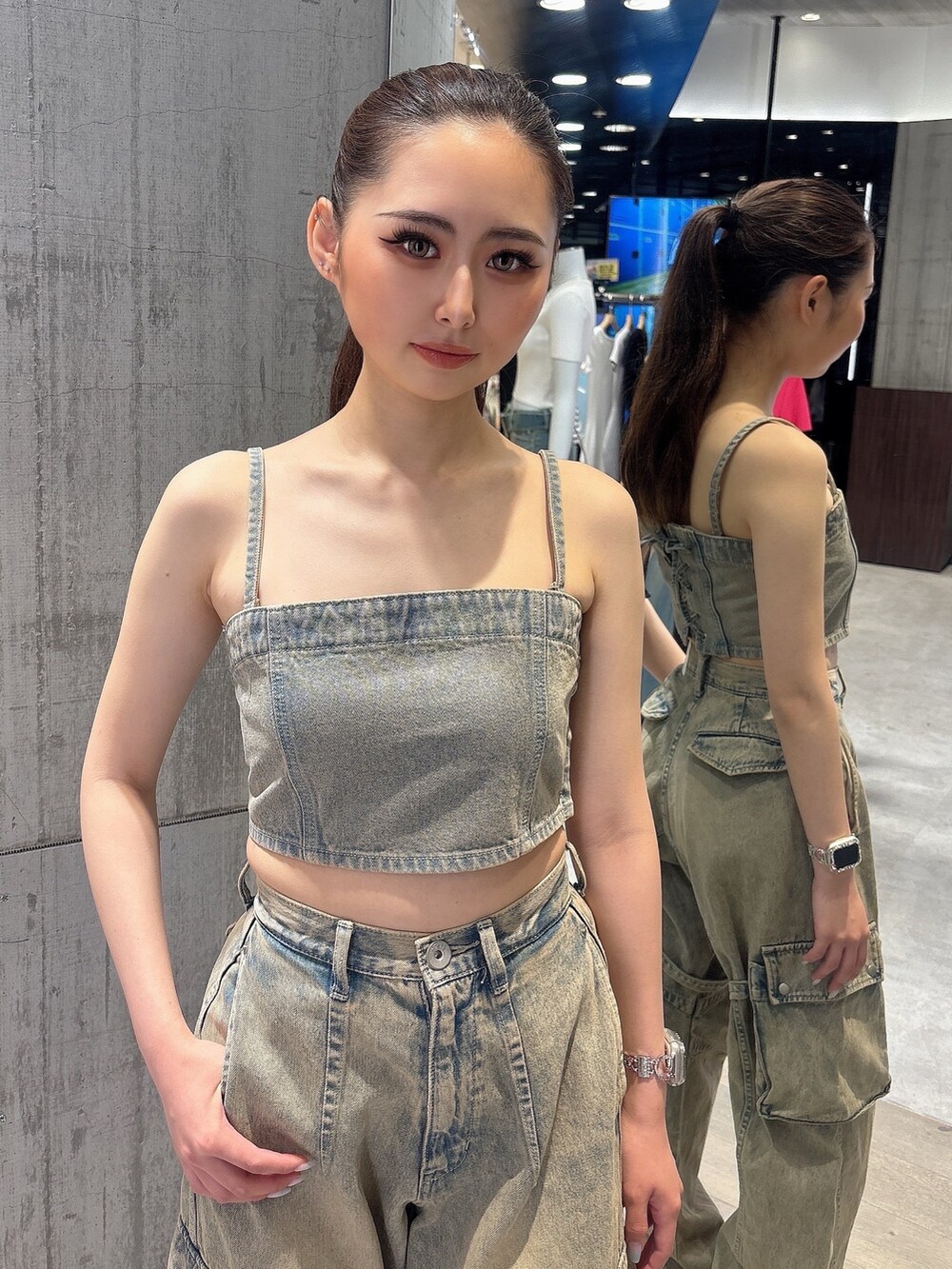 ブルー系のデニムパンツ、ブルー系のキャミソール、ホワイト系のサンダルを着用したレディースの夏コーディネートの5枚目の写真