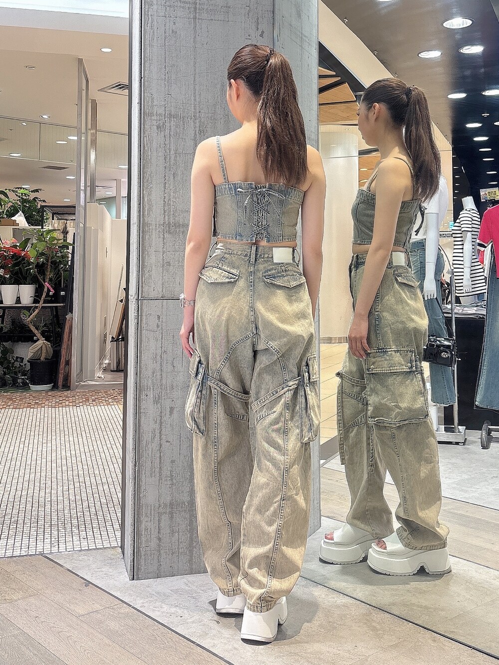 ブルー系のデニムパンツ、ブルー系のキャミソール、ホワイト系のサンダルを着用したレディースの夏コーディネートの4枚目の写真