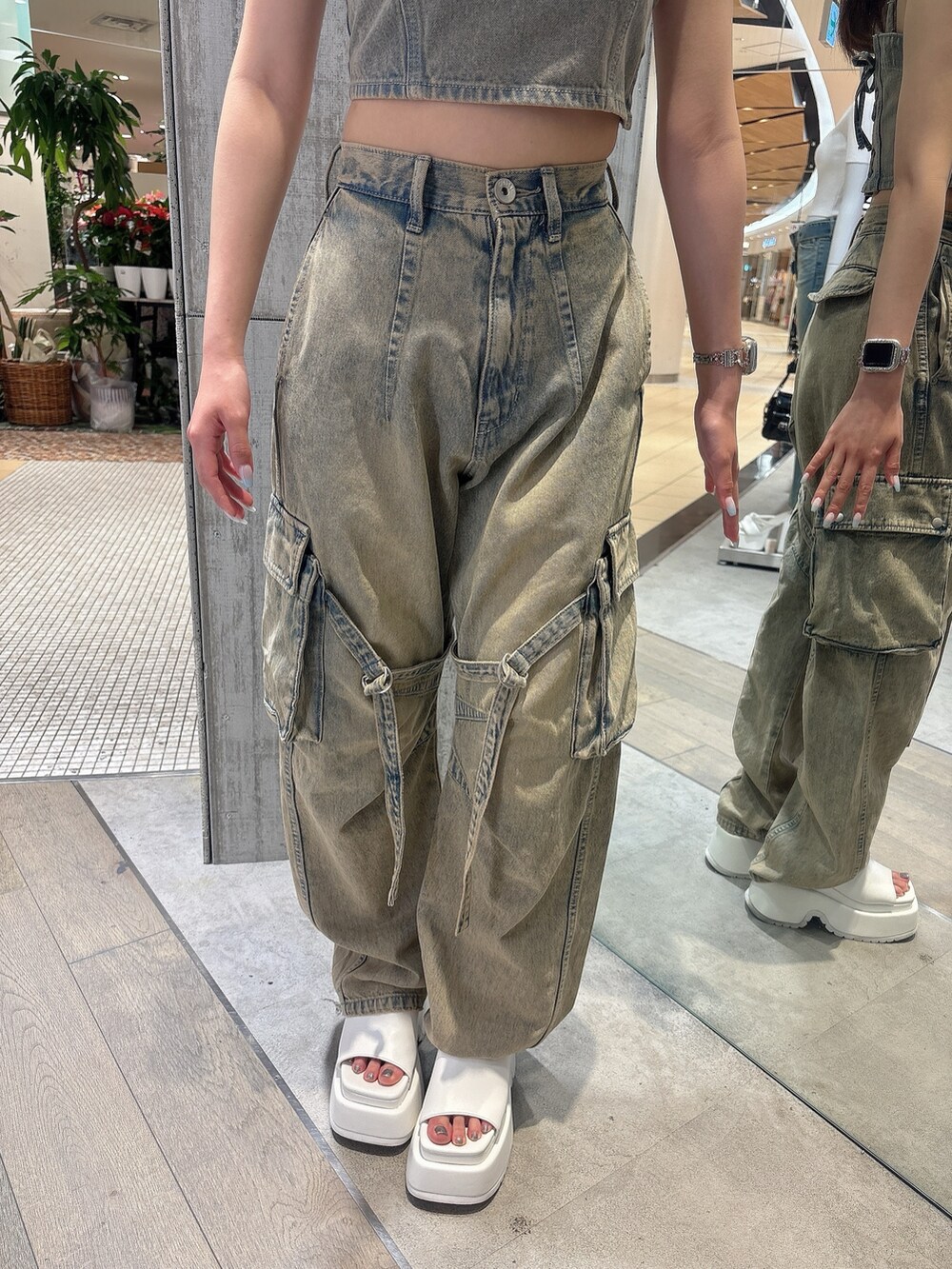 ブルー系のデニムパンツ、ブルー系のキャミソール、ホワイト系のサンダルを着用したレディースの夏コーディネートの7枚目の写真