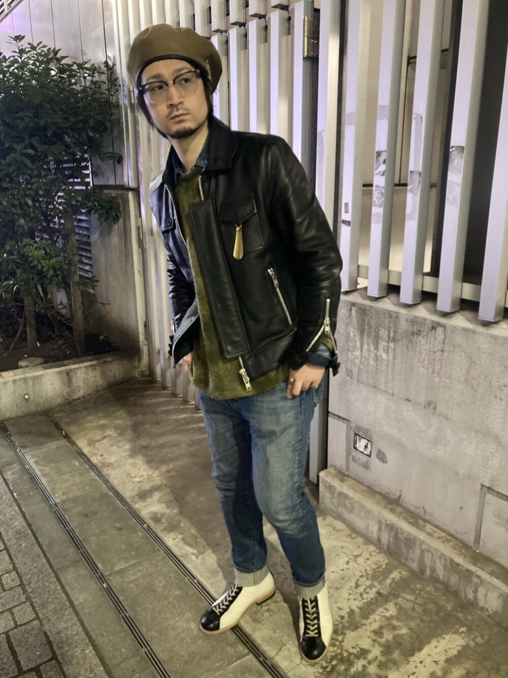 ホワイト系のブーツ、ブルー系のデニムパンツ、ブラック系のライダースジャケットを着用したメンズの春コーディネートの2枚目の写真