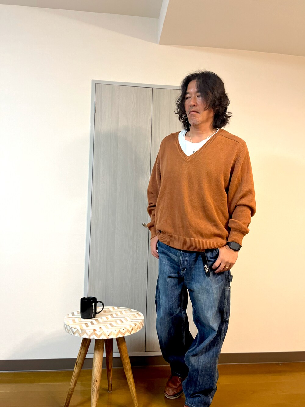 ブラウン系のニット/セーター、ブルー系のデニムパンツ、ブラウン系のブーツを着用したメンズの冬コーディネートの3枚目の写真