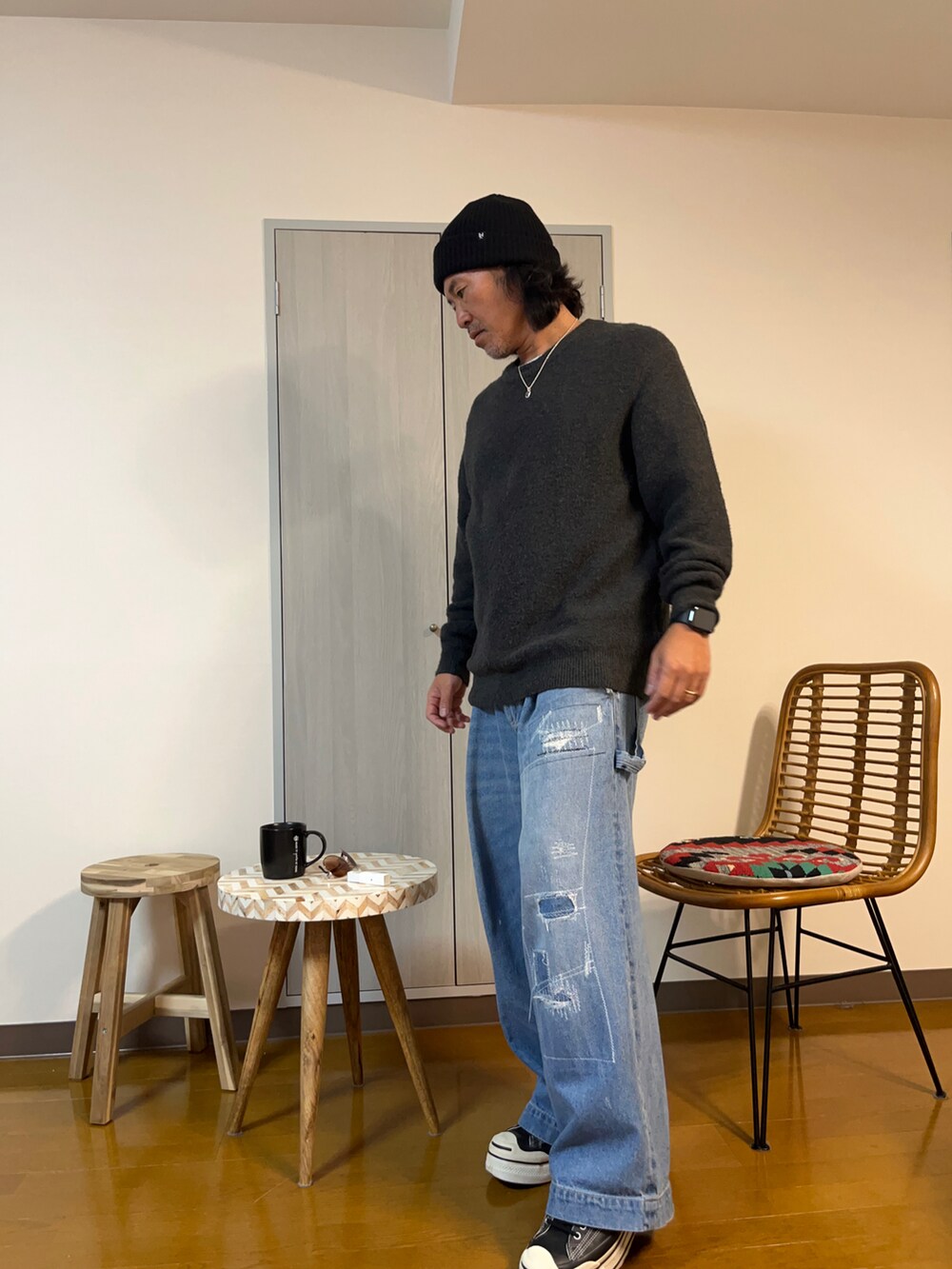 グレー系のニット/セーター、ブルー系のデニムパンツ、ブラック系のスニーカーを着用したメンズの冬コーディネートの3枚目の写真