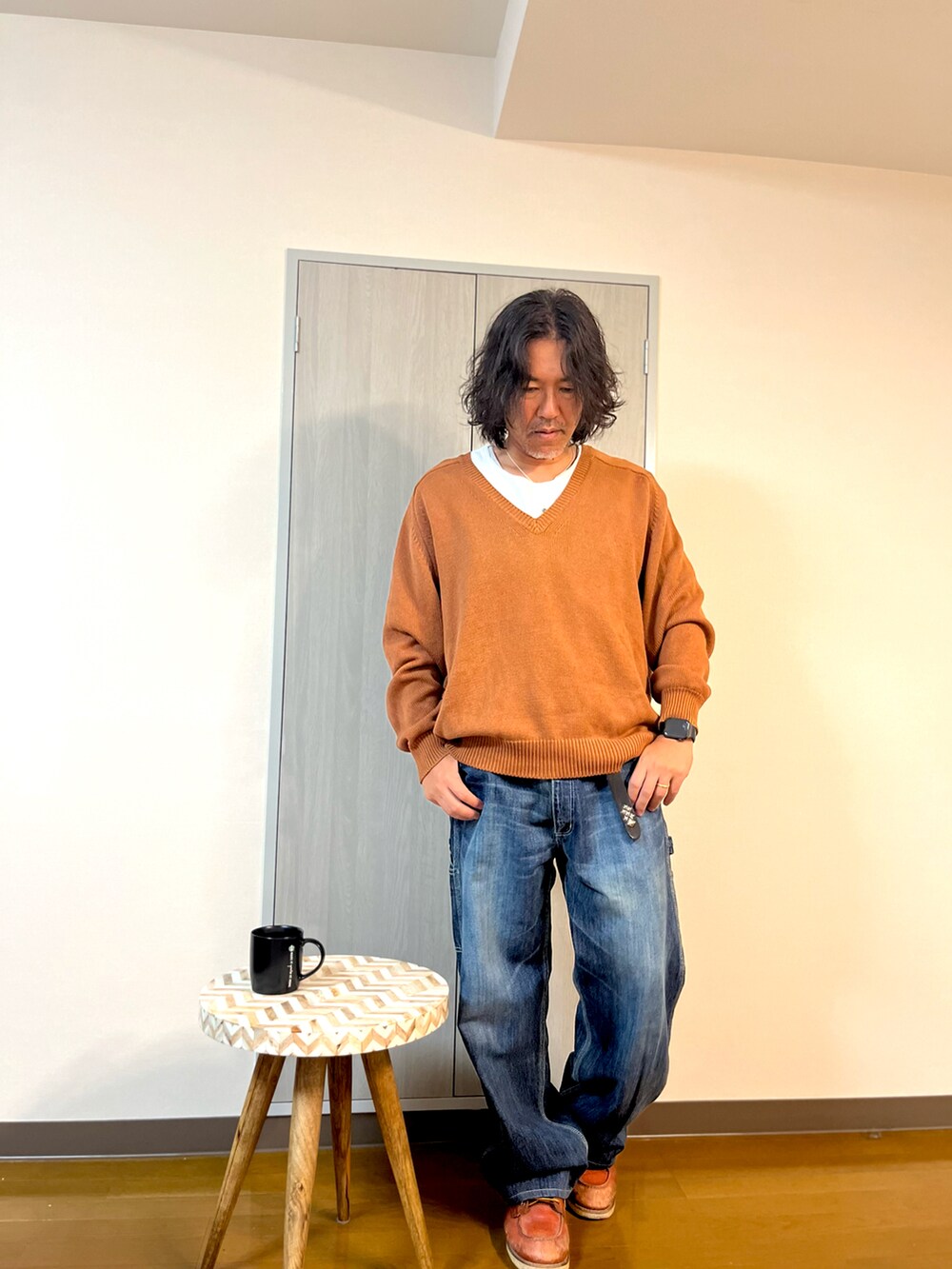 ブラウン系のニット/セーター、ブルー系のデニムパンツ、ブラウン系のブーツを着用したメンズの冬コーディネートの2枚目の写真