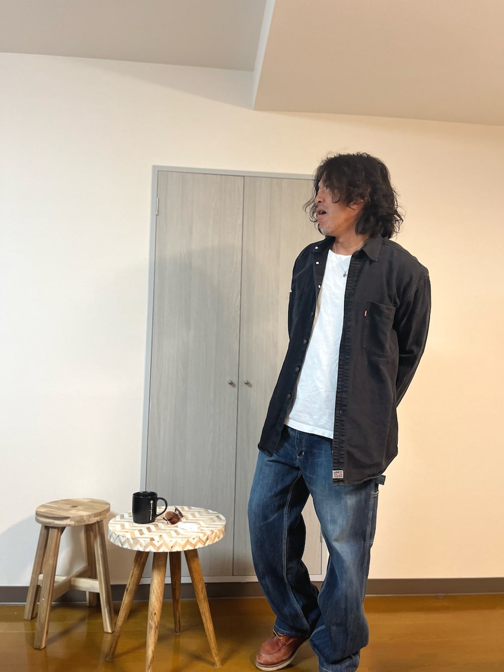 ブラック系のシャツ/ブラウス、ブルー系のデニムパンツ、ブラウン系のブーツを着用したメンズの冬コーディネートの2枚目の写真