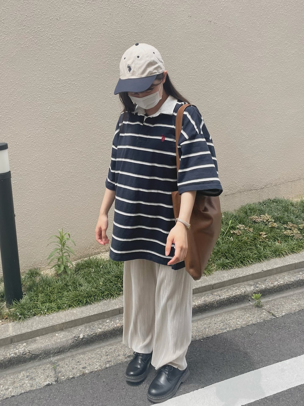 ブルー系のポロシャツ、ブラウン系のトートバッグ、ホワイト系のその他パンツを着用したレディースの夏コーディネートの3枚目の写真