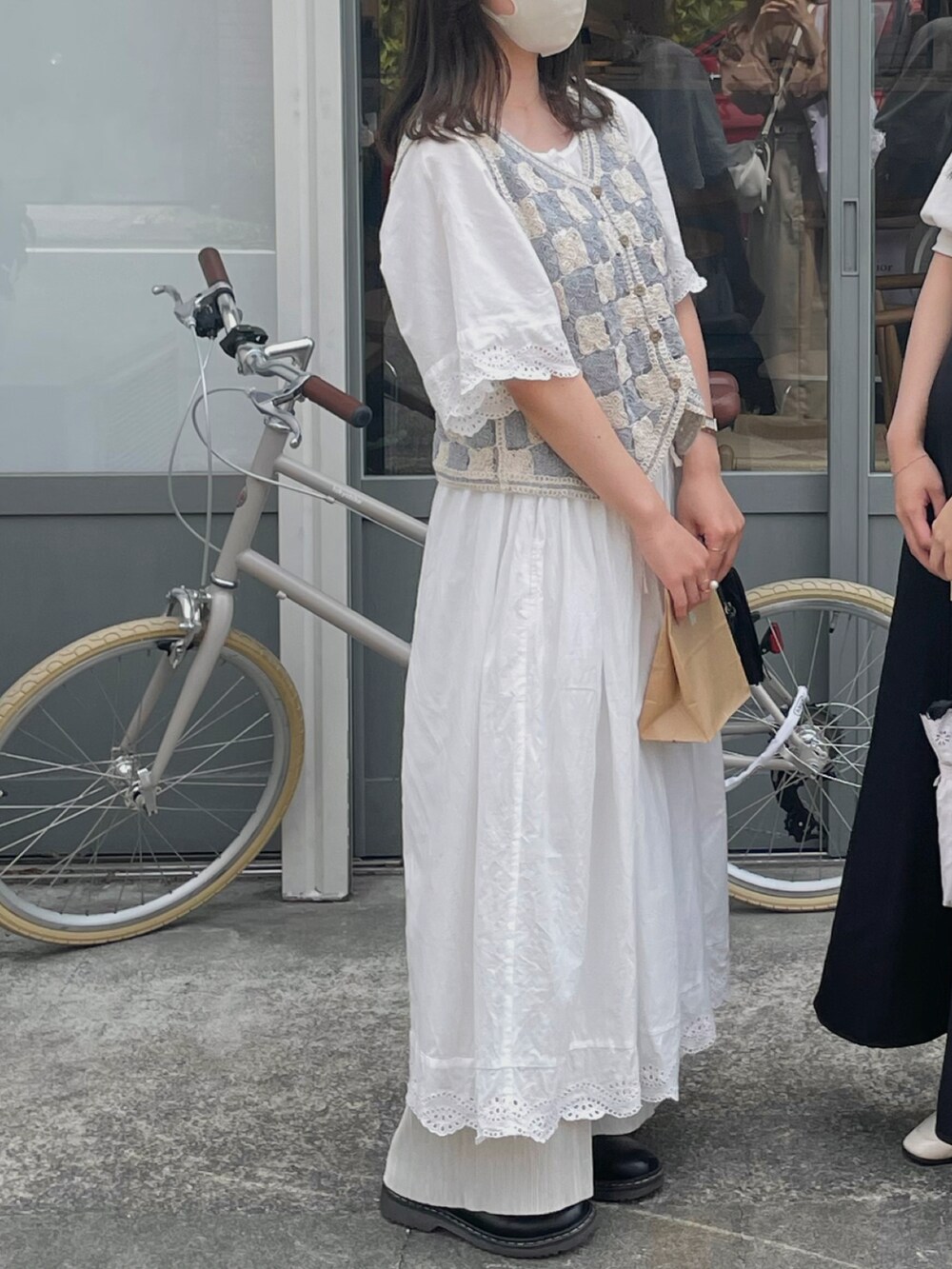 ベージュ系のベスト、ホワイト系のワンピース、ホワイト系のその他パンツを着用したレディースの夏コーディネートの2枚目の写真