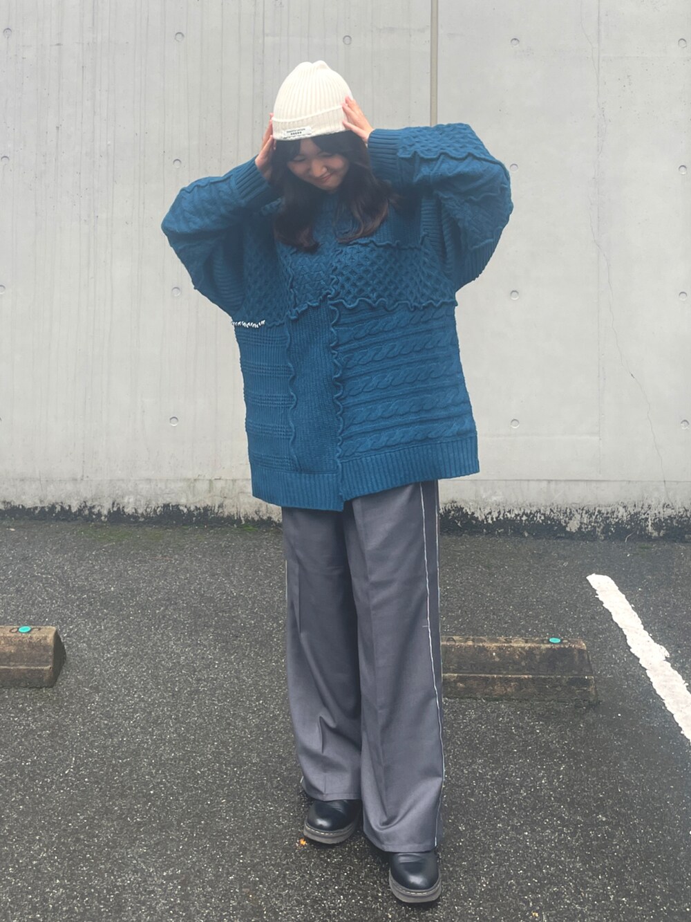 ブルー系のニット/セーター、グレー系のスラックス、ホワイト系のトートバッグを着用したレディースの秋コーディネートの4枚目の写真