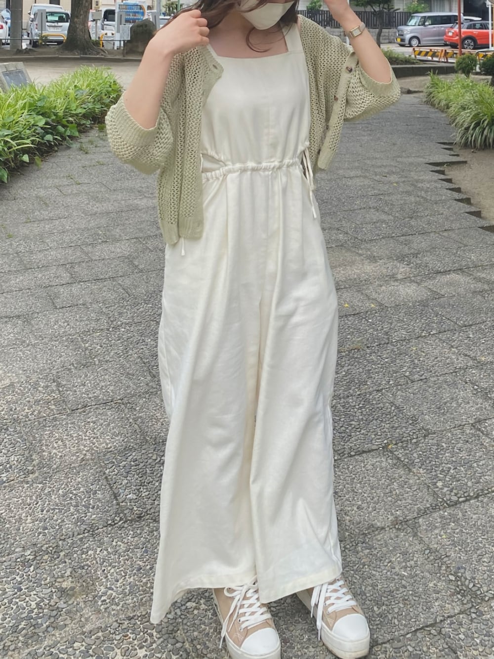 ホワイト系のサロペット/オーバーオール、グリーン系のカーディガン/ボレロ、ベージュ系のスニーカーを着用したレディースの夏コーディネートの2枚目の写真