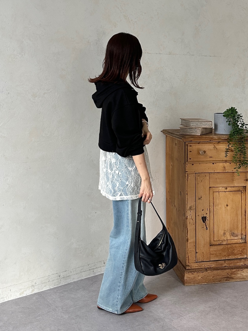 ブラック系のパーカー、ホワイト系のチュニック、ブルー系のその他パンツを着用したレディースの冬コーディネートの5枚目の写真