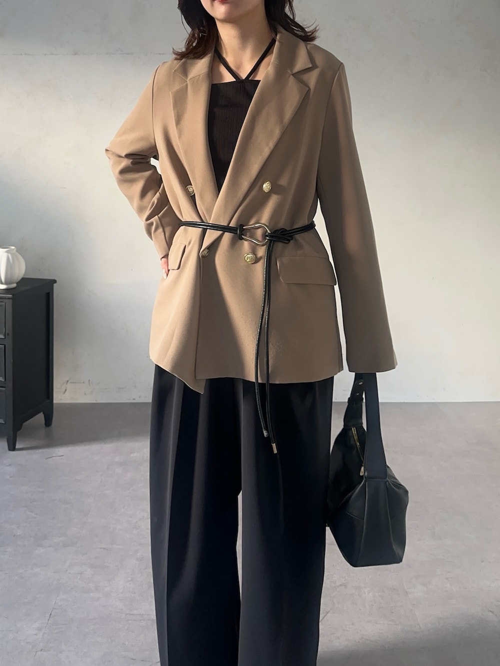 ブラック系のスラックス、ブラック系のTシャツ/カットソー、ベージュ系のテーラードジャケットを着用したレディースの秋コーディネートの4枚目の写真