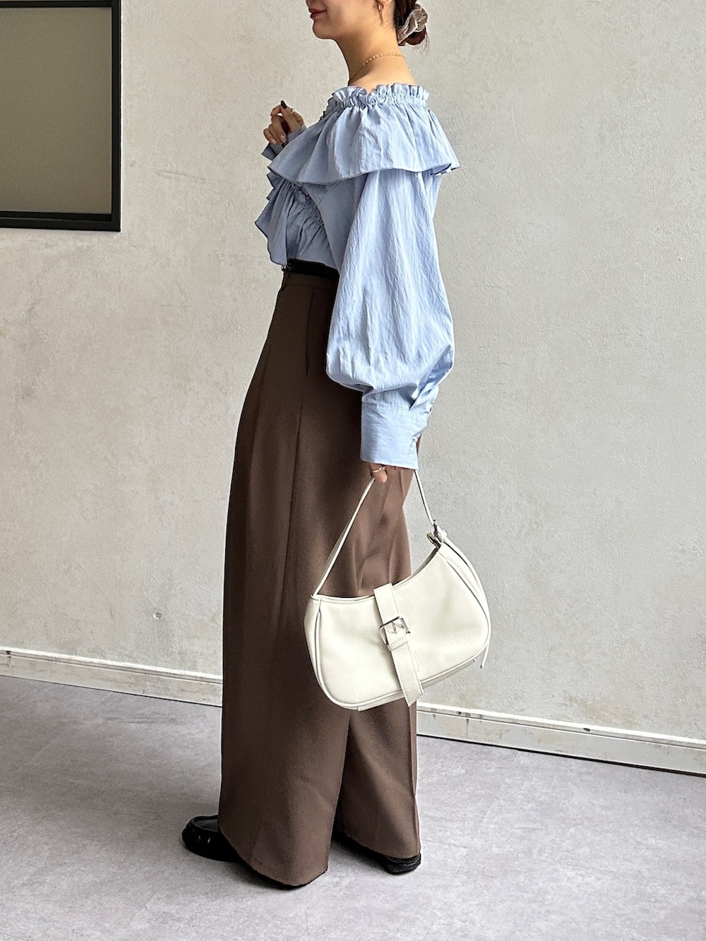 ブルー系のシャツ/ブラウス、ブラウン系のスラックス、ブラック系のベルトを着用したレディースの冬コーディネートの2枚目の写真