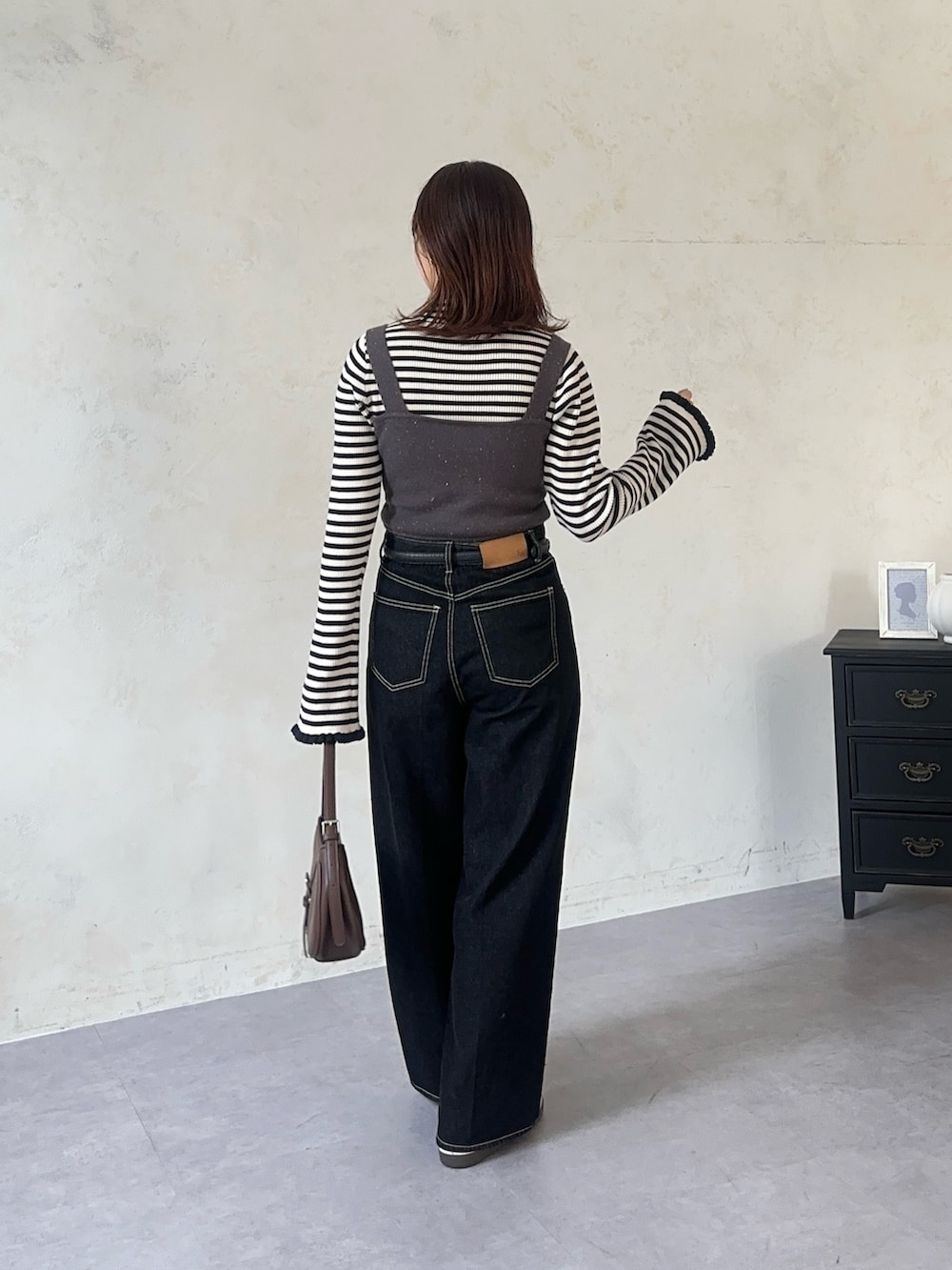 ホワイト系のニット/セーター、グレー系のワンピース、ブルー系のその他パンツを着用したレディースの秋コーディネートの4枚目の写真