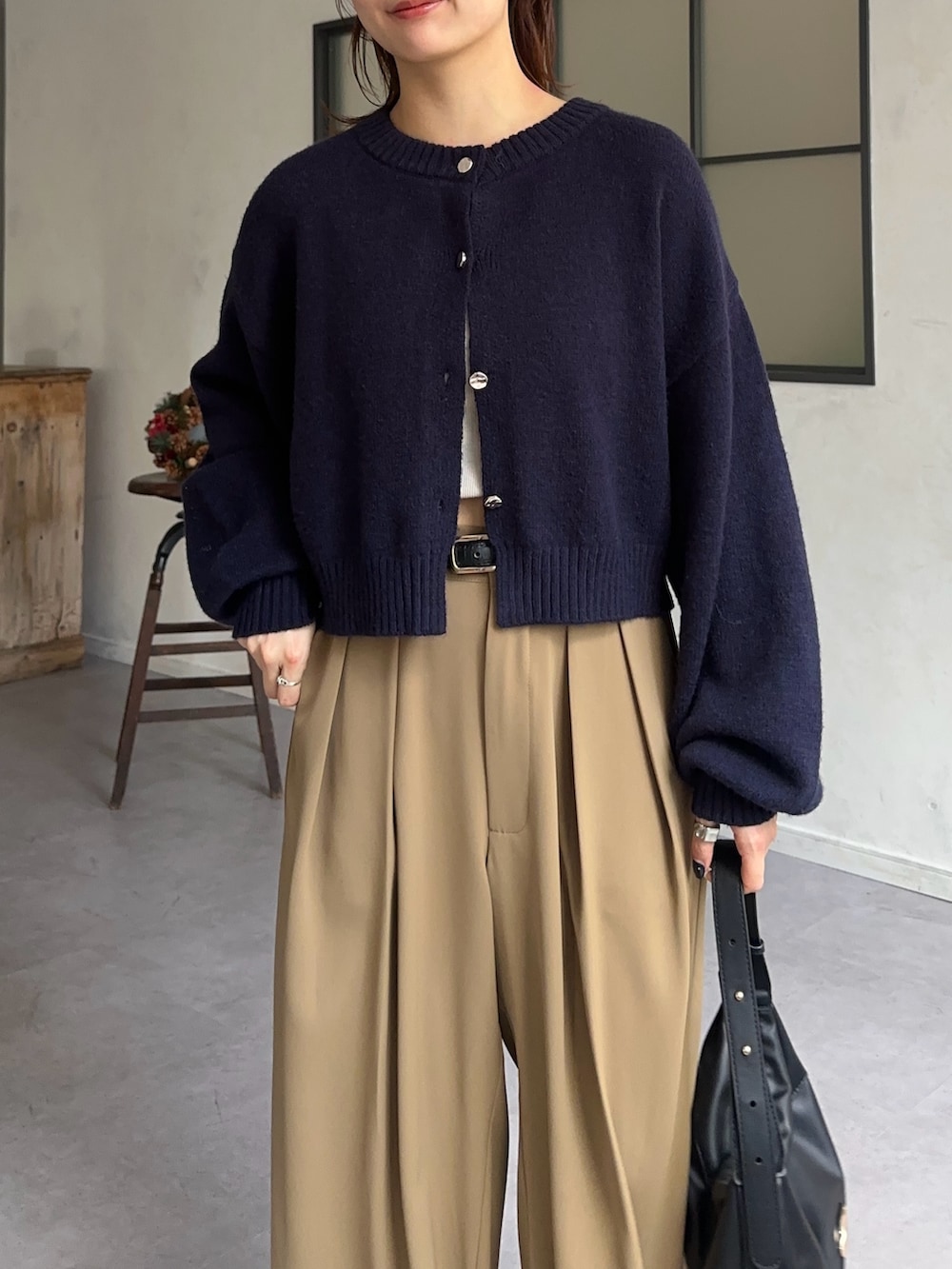 ブルー系のカーディガン/ボレロ、イエロー系のスラックスを着用したレディースの冬コーディネートの2枚目の写真