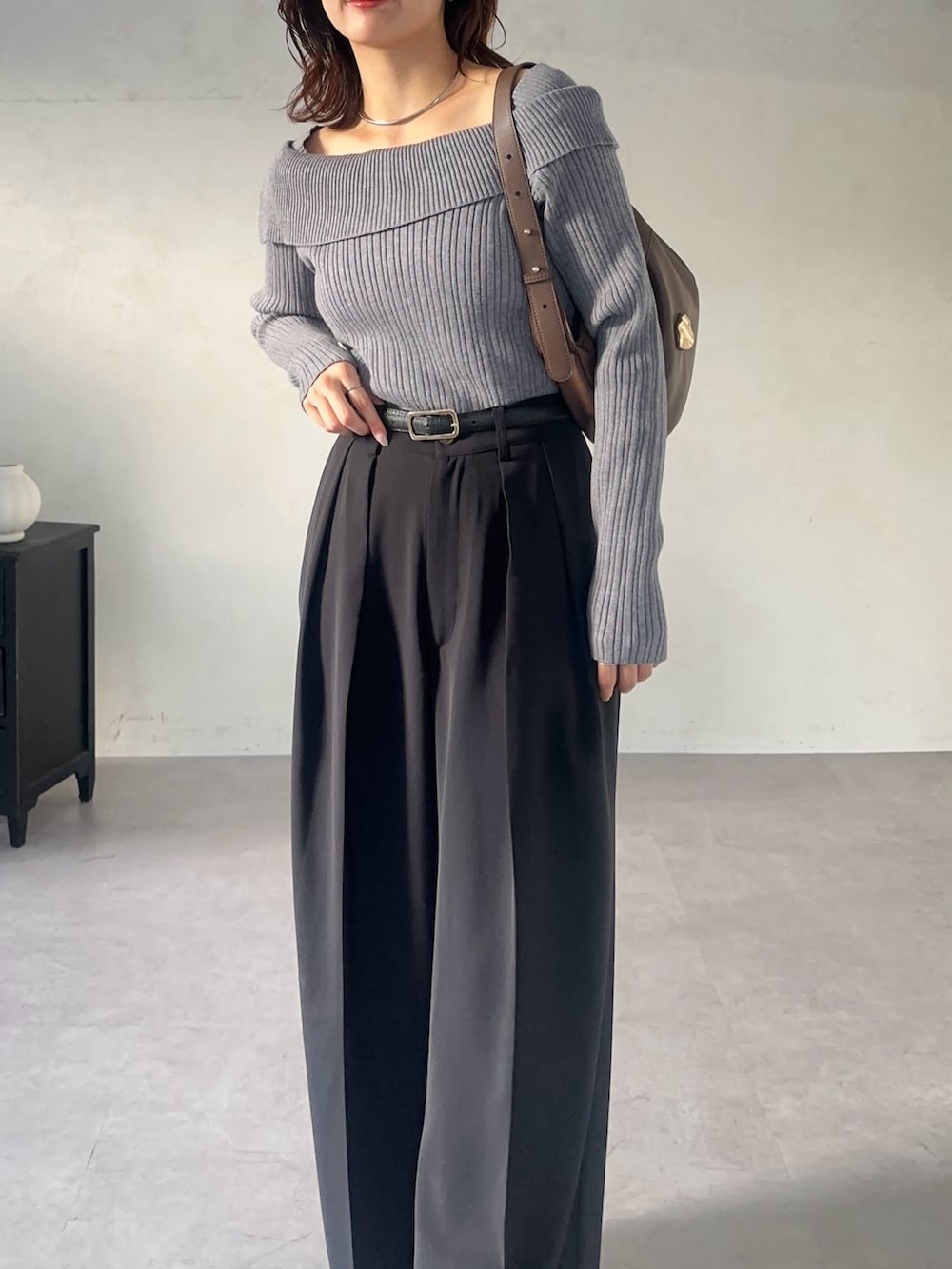 ブラック系のスラックス、グレー系のニット/セーター、ブラック系のベルトを着用したレディースの秋コーディネートの5枚目の写真