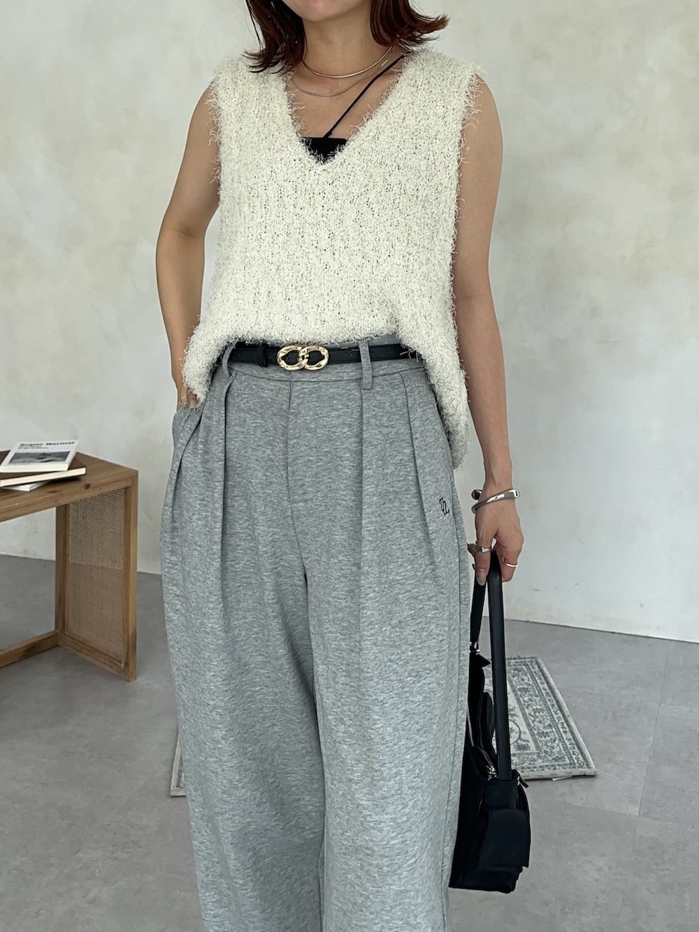 ホワイト系のニット/セーター、ブラック系のトートバッグ、グレー系のその他パンツを着用したレディースの夏コーディネートの6枚目の写真