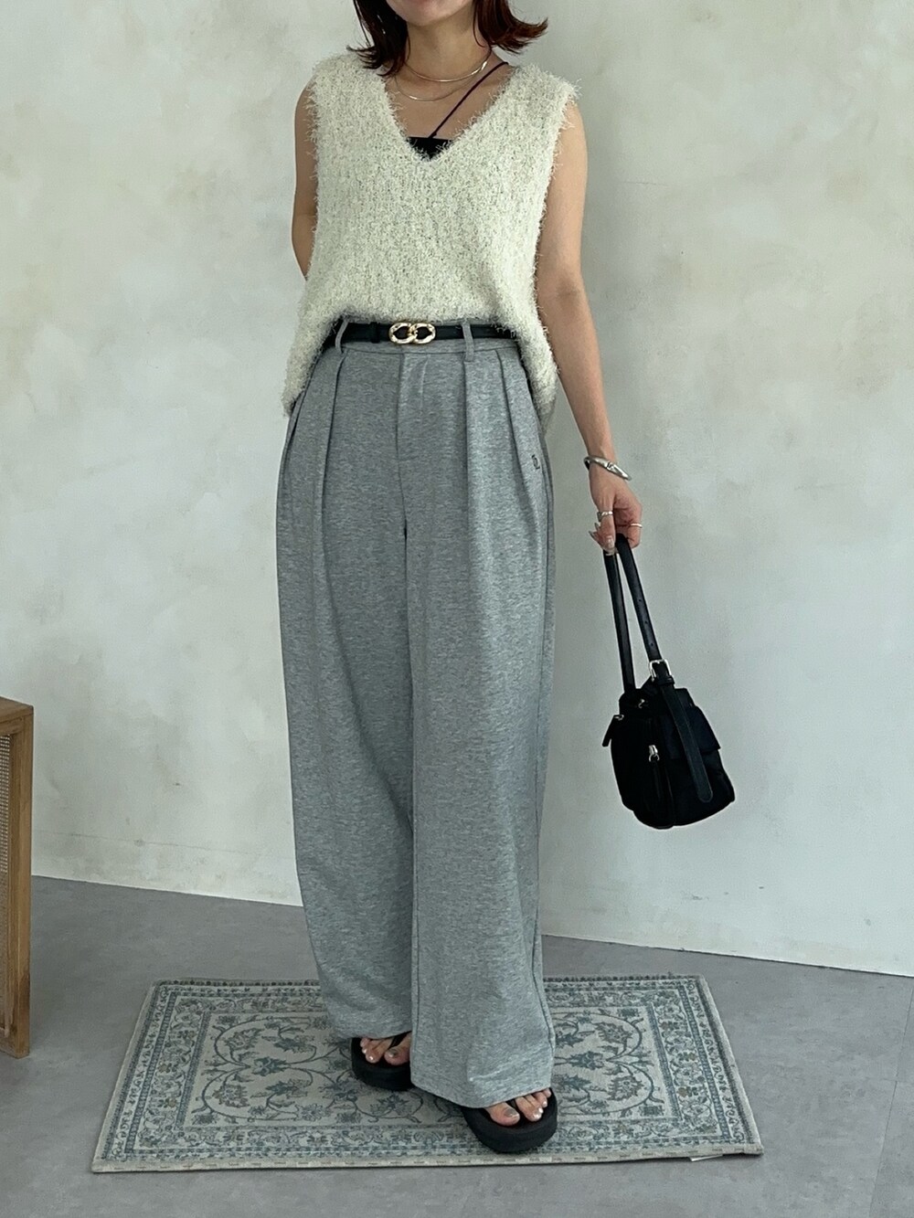 ホワイト系のニット/セーター、ブラック系のトートバッグ、グレー系のその他パンツを着用したレディースの夏コーディネートの4枚目の写真