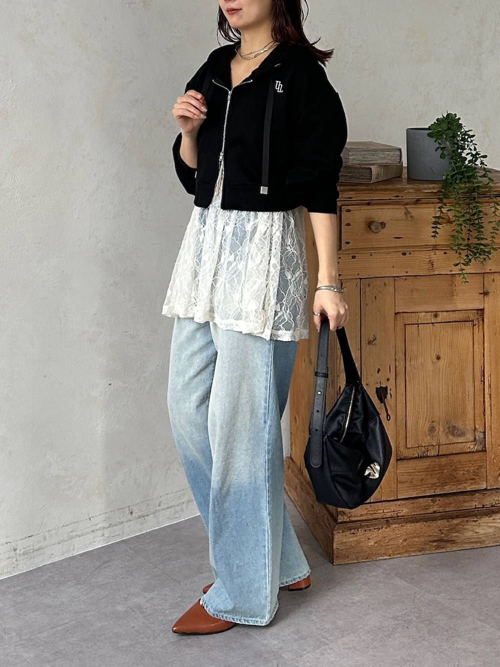 ブラック系のパーカー、ホワイト系のチュニック、ブルー系のその他パンツを着用したレディースの冬コーディネートの3枚目の写真