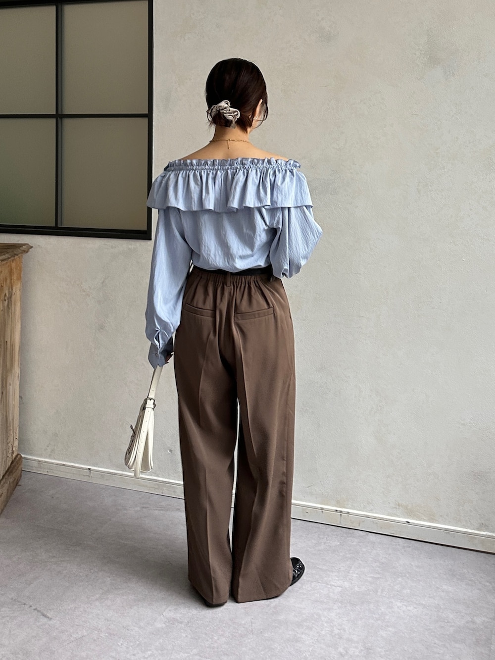 ブルー系のシャツ/ブラウス、ブラウン系のスラックス、ブラック系のベルトを着用したレディースの冬コーディネートの4枚目の写真