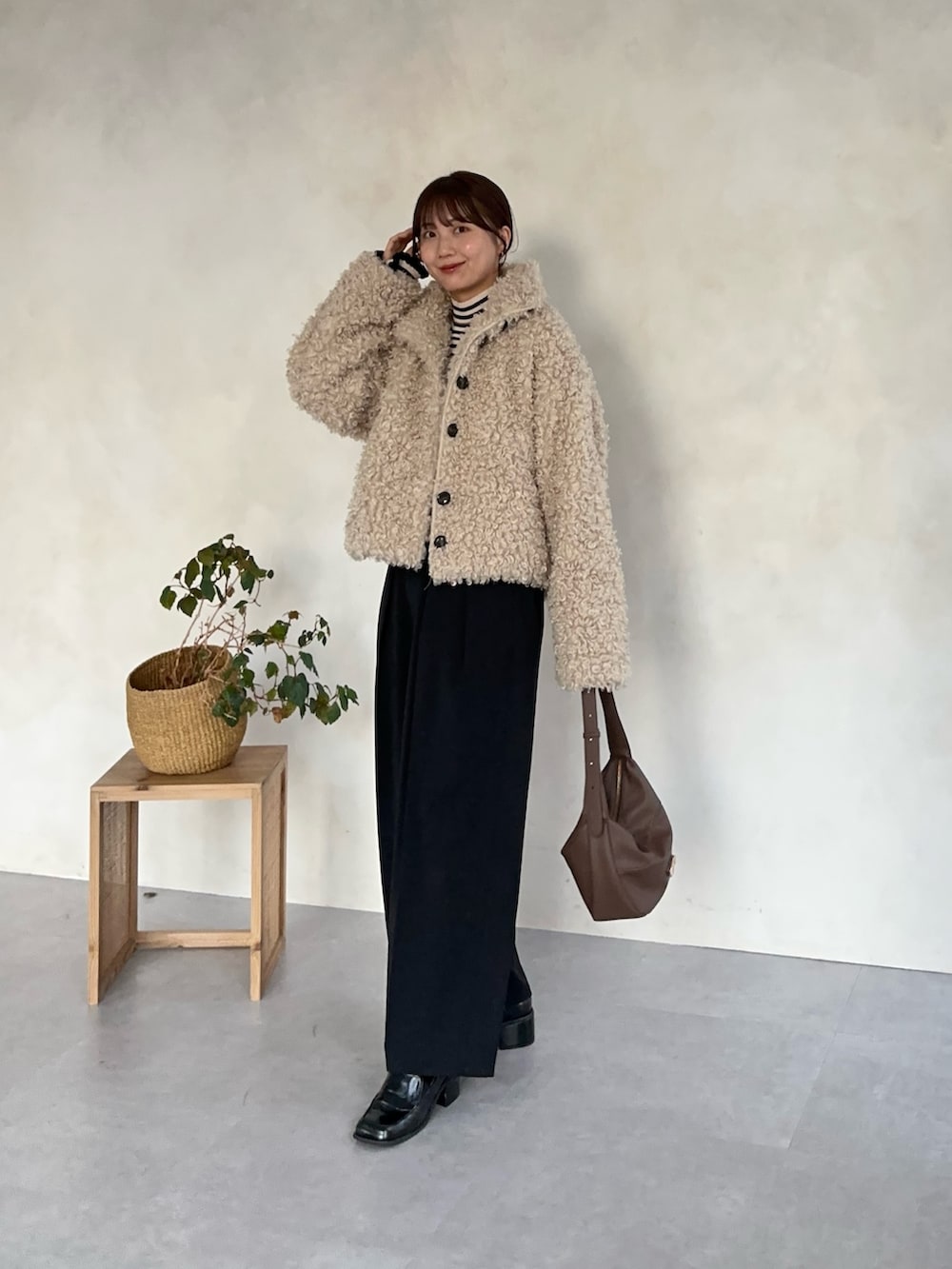 ブラック系のスラックス、ホワイト系のブルゾン、ブラック系のニット/セーターを着用したレディースの冬コーディネートの2枚目の写真