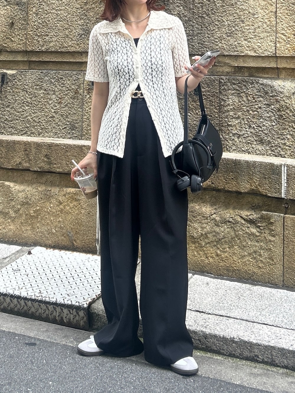 ブラック系のスラックス、ブラック系のボストンバッグ、ブラック系のベルトを着用したレディースの夏コーディネートの3枚目の写真