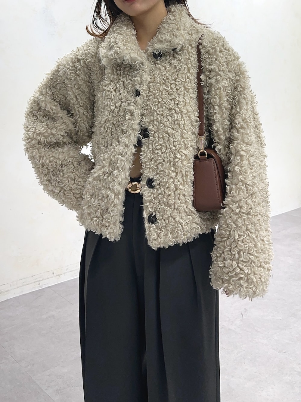 ホワイト系のブルゾン、グレー系のスラックス、ベージュ系のベルトを着用したレディースの冬コーディネートの4枚目の写真