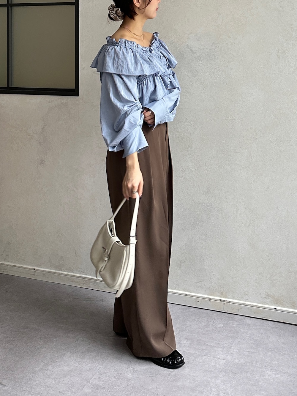 ブルー系のシャツ/ブラウス、ブラウン系のスラックス、ブラック系のベルトを着用したレディースの冬コーディネートの3枚目の写真