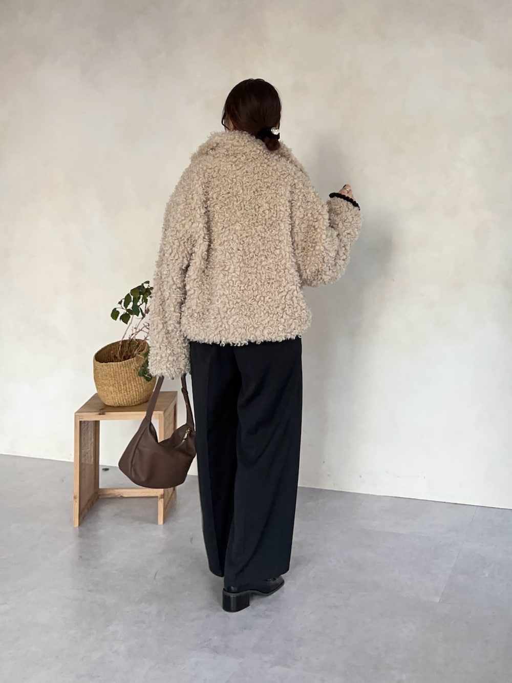 ブラック系のスラックス、ホワイト系のブルゾン、ブラック系のニット/セーターを着用したレディースの冬コーディネートの4枚目の写真