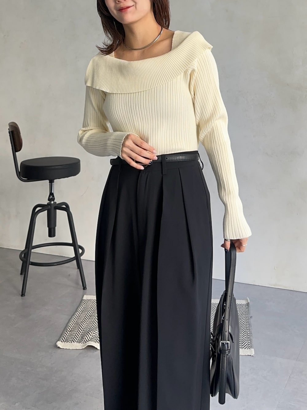 ホワイト系のニット/セーター、ブラック系のスラックス、グレー系のその他アウターを着用したレディースの冬コーディネートの3枚目の写真