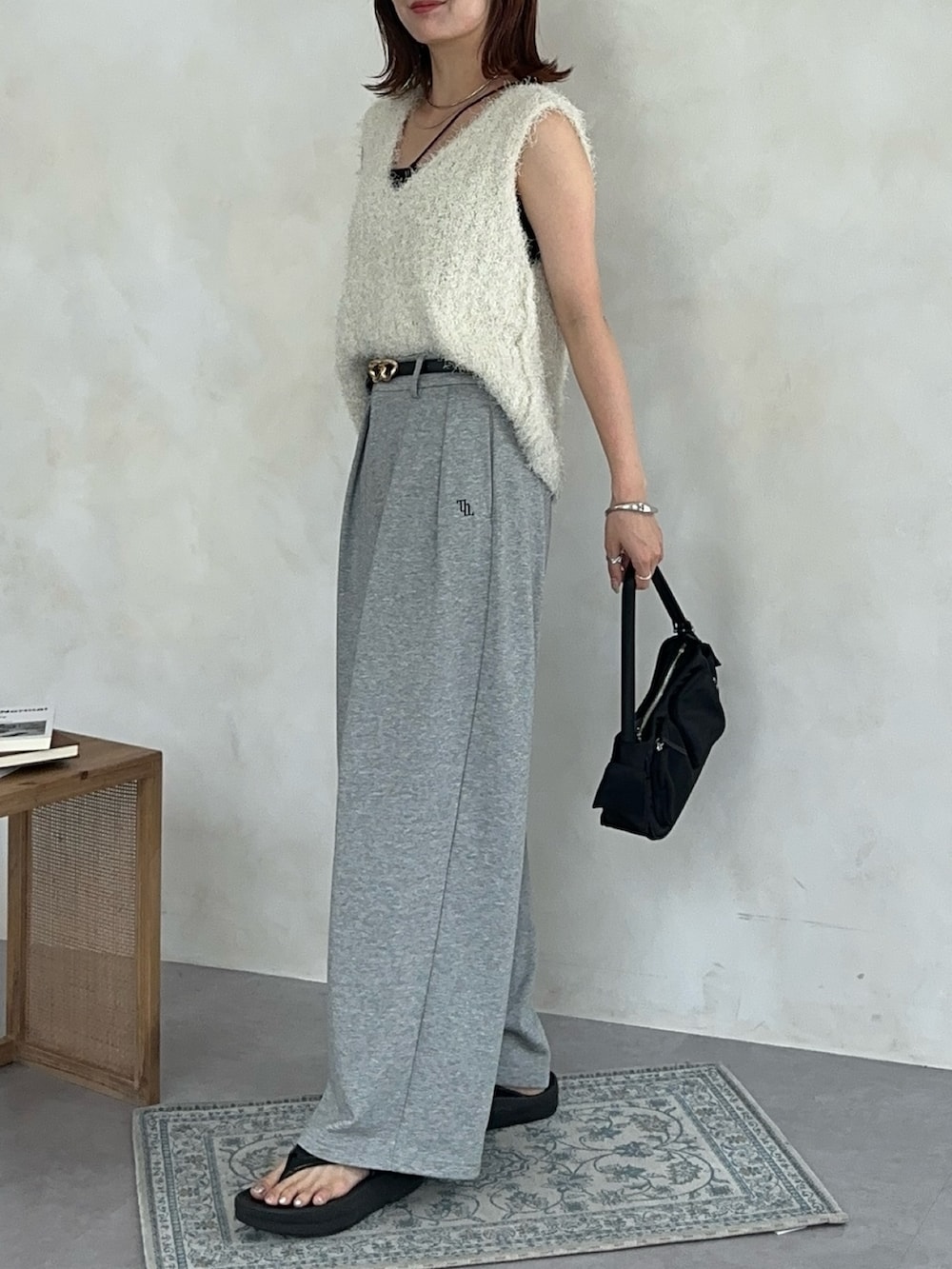 ホワイト系のニット/セーター、ブラック系のトートバッグ、グレー系のその他パンツを着用したレディースの夏コーディネートの2枚目の写真