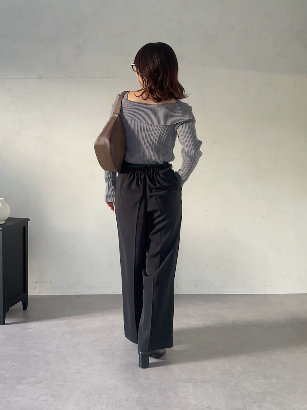 ブラック系のスラックス、グレー系のニット/セーター、ブラック系のベルトを着用したレディースの秋コーディネートの3枚目の写真