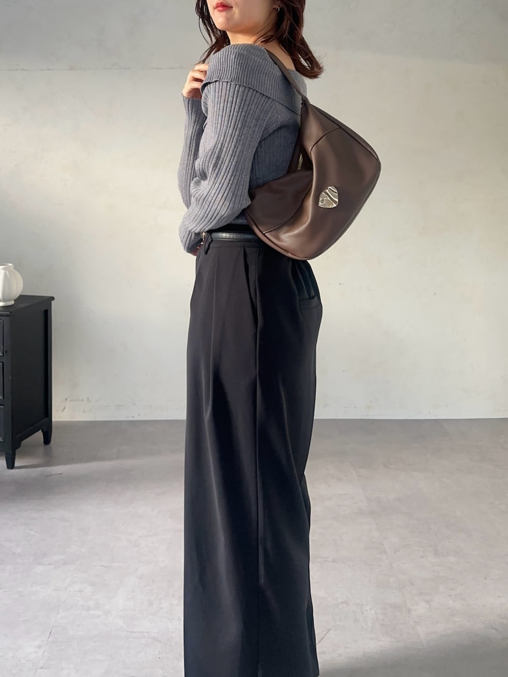 ブラック系のスラックス、グレー系のニット/セーター、ブラック系のベルトを着用したレディースの秋コーディネートの4枚目の写真