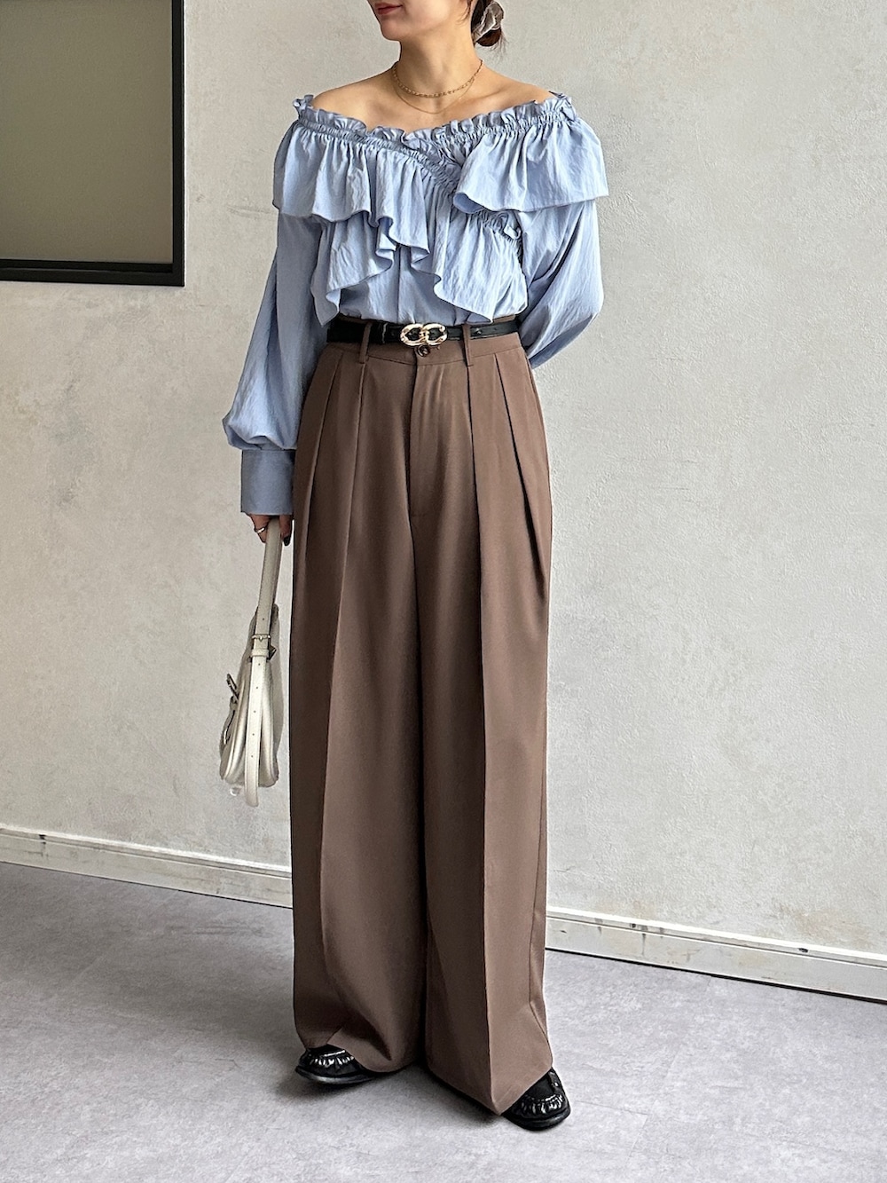 ブルー系のシャツ/ブラウス、ブラウン系のスラックス、ブラック系のベルトを着用したレディースの冬コーディネートの5枚目の写真