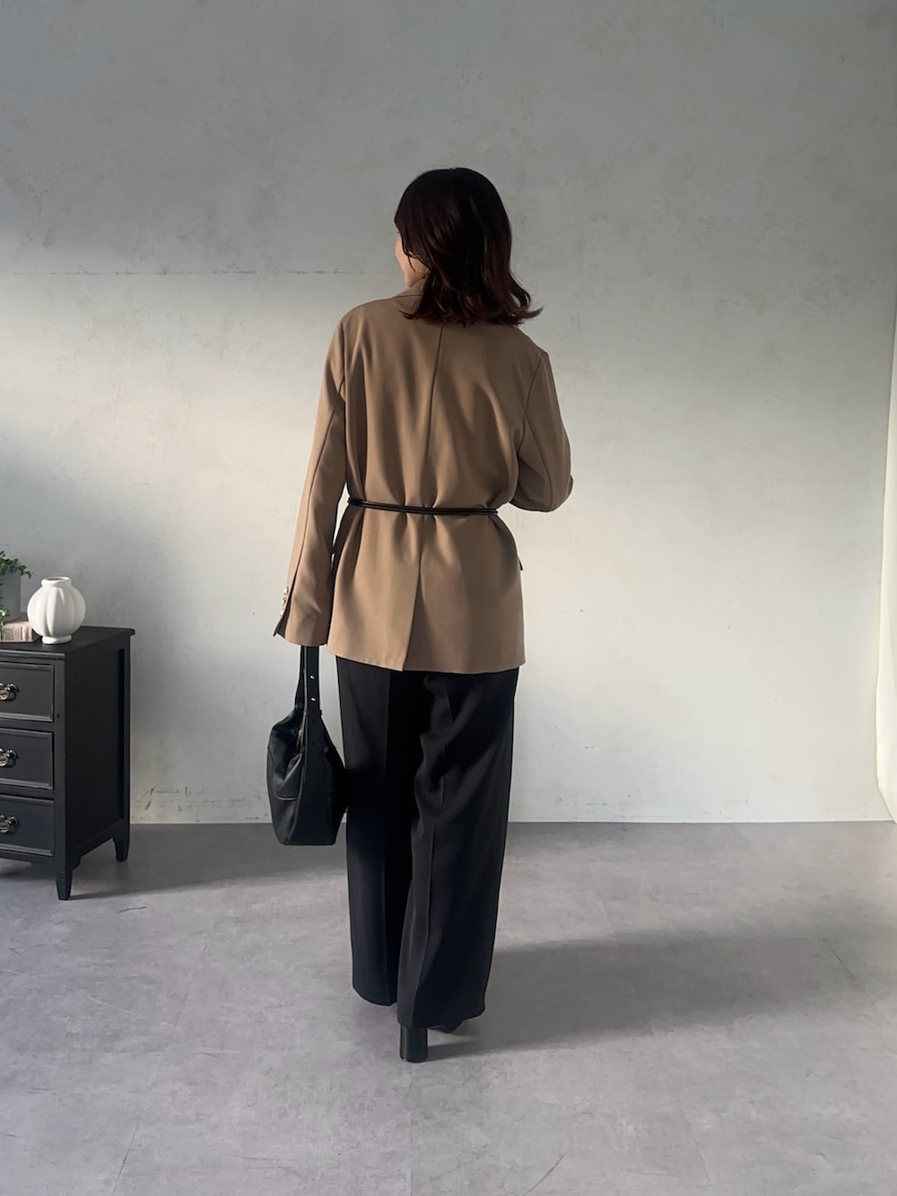 ブラック系のスラックス、ブラック系のTシャツ/カットソー、ベージュ系のテーラードジャケットを着用したレディースの秋コーディネートの2枚目の写真