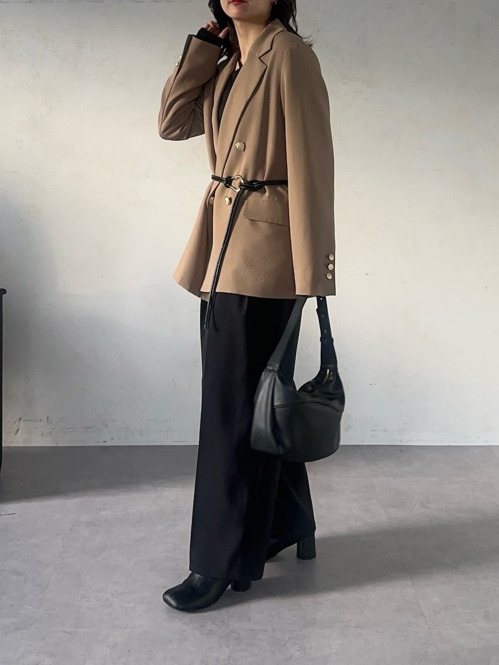 ブラック系のスラックス、ブラック系のTシャツ/カットソー、ベージュ系のテーラードジャケットを着用したレディースの秋コーディネートの3枚目の写真