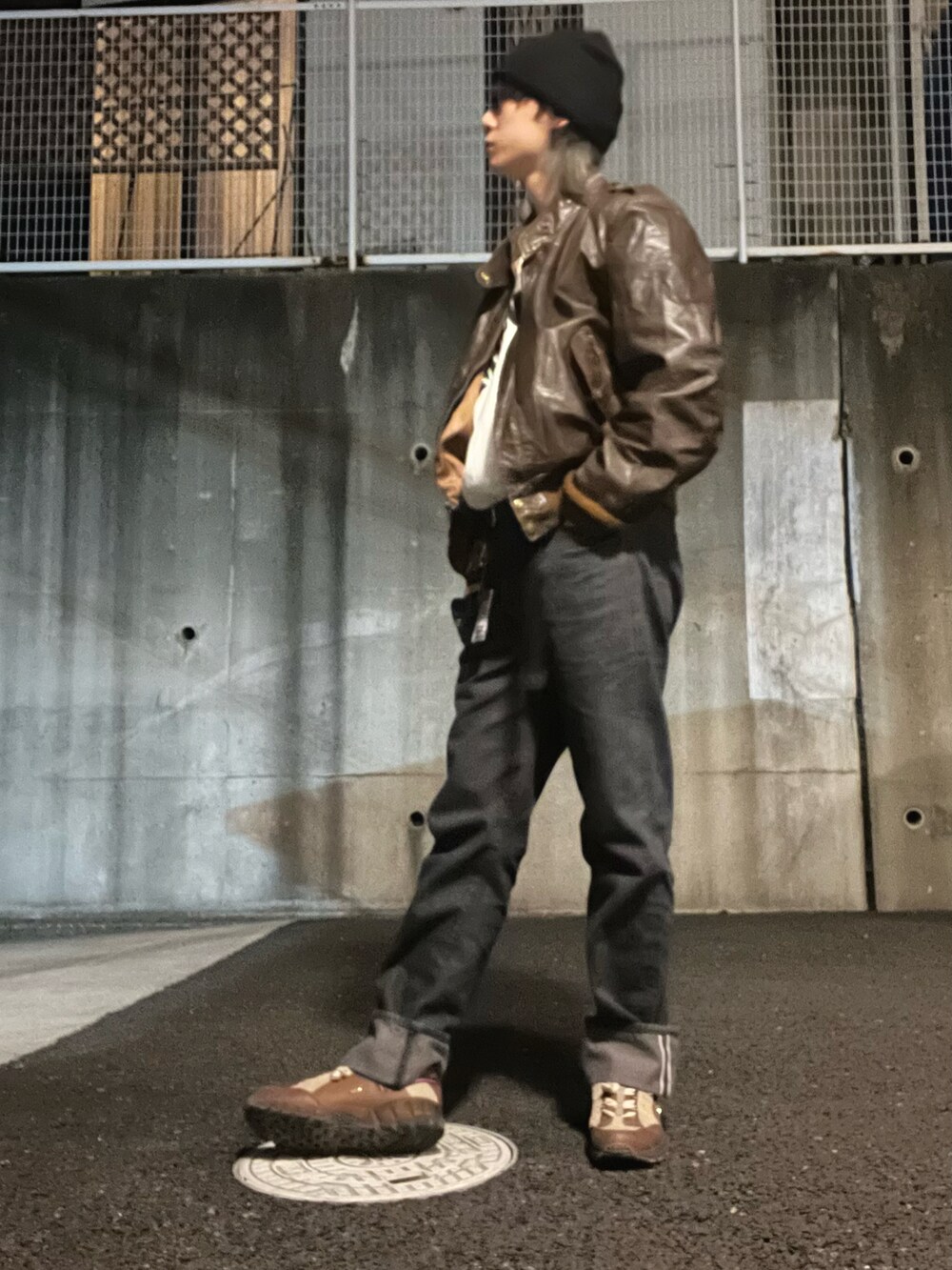 ブラック系のデニムパンツ、ホワイト系のスウェット、ブラウン系のライダースジャケットを着用したメンズの春コーディネートの5枚目の写真