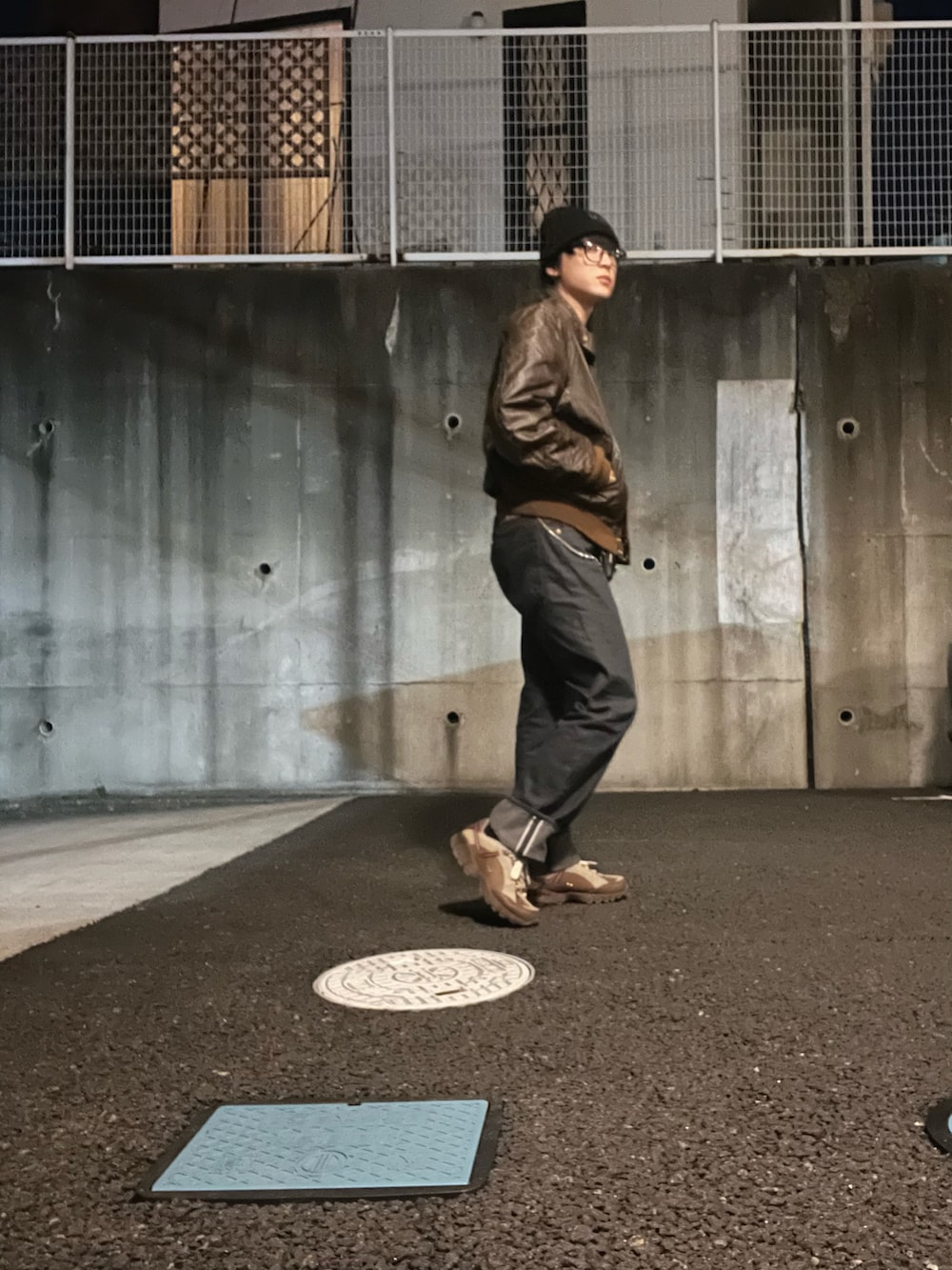 ブラック系のデニムパンツ、ホワイト系のスウェット、ブラウン系のライダースジャケットを着用したメンズの春コーディネートの2枚目の写真