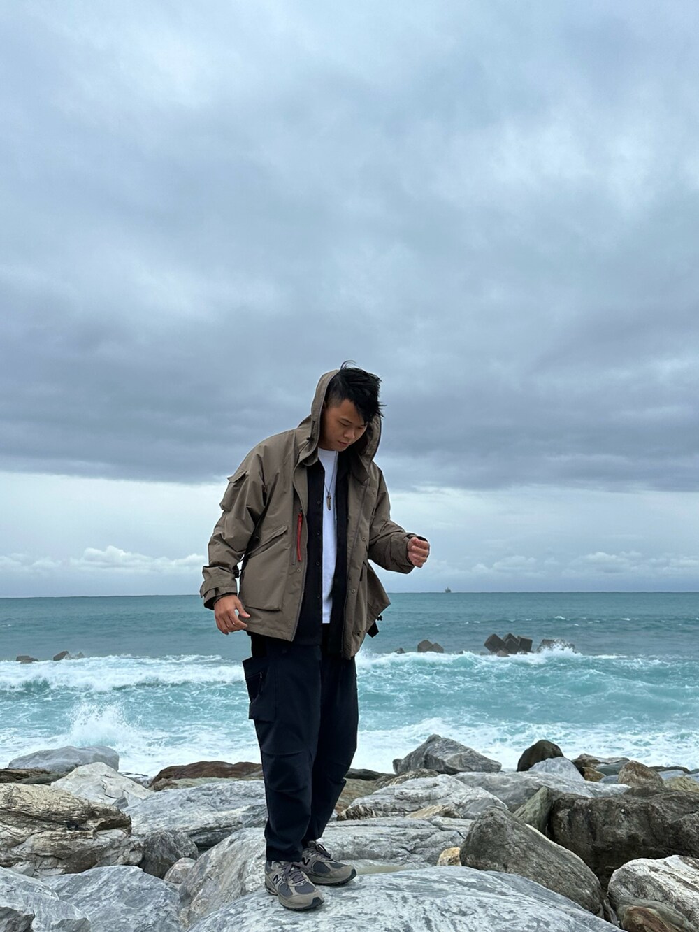 ブラック系のシャツ/ブラウス、ブラウン系のマウンテンパーカー、ブラック系のパンツを着用したメンズの春コーディネートの3枚目の写真