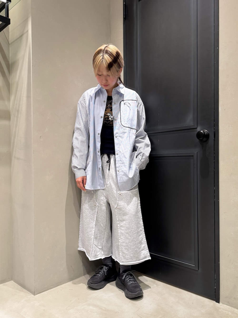 ブラック系のスニーカー、グレー系のその他パンツを着用したレディースの春コーディネートの2枚目の写真