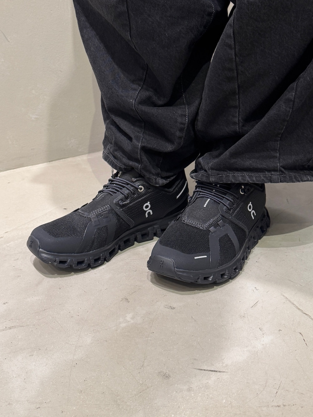 ブラック系のショルダーバッグ、ブラック系のスニーカー、パープル系のスマホグッズを着用したレディースの夏コーディネートの5枚目の写真