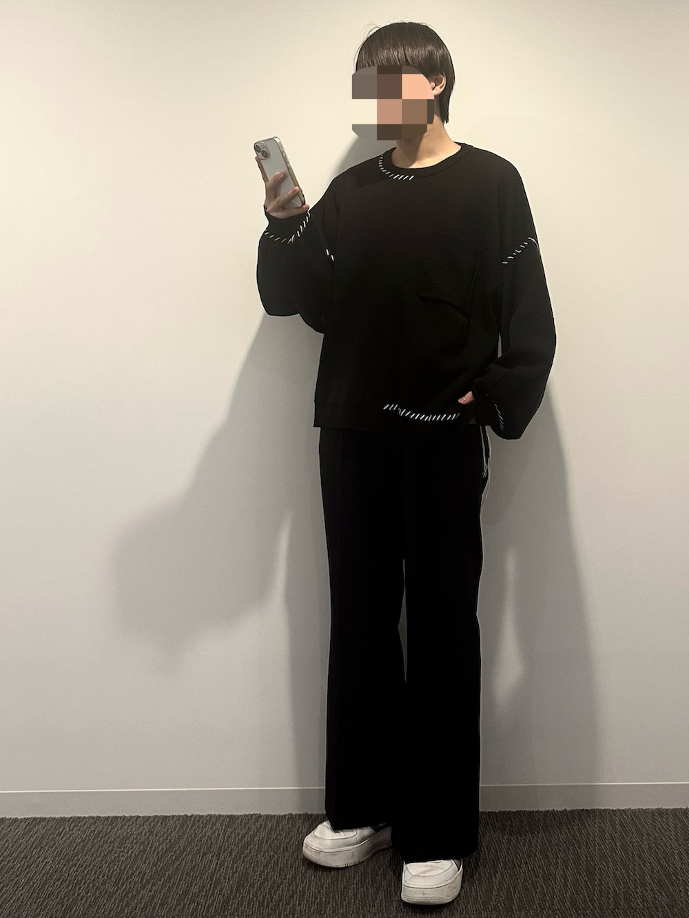 ブラック系のスラックス、ブラック系のニット/セーター、ベージュ系のシャツ/ブラウスを着用したメンズの秋コーディネートの2枚目の写真