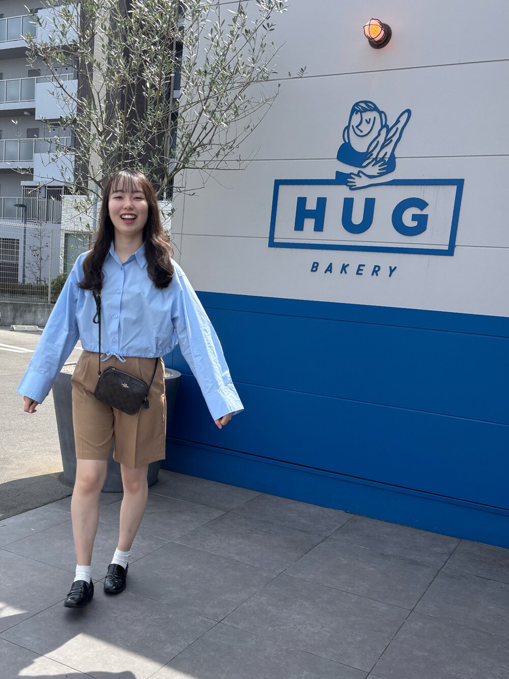 ブルー系のシャツ/ブラウス、ブラウン系のその他パンツ、ブラウン系のショルダーバッグを着用したレディースの春コーディネートの3枚目の写真