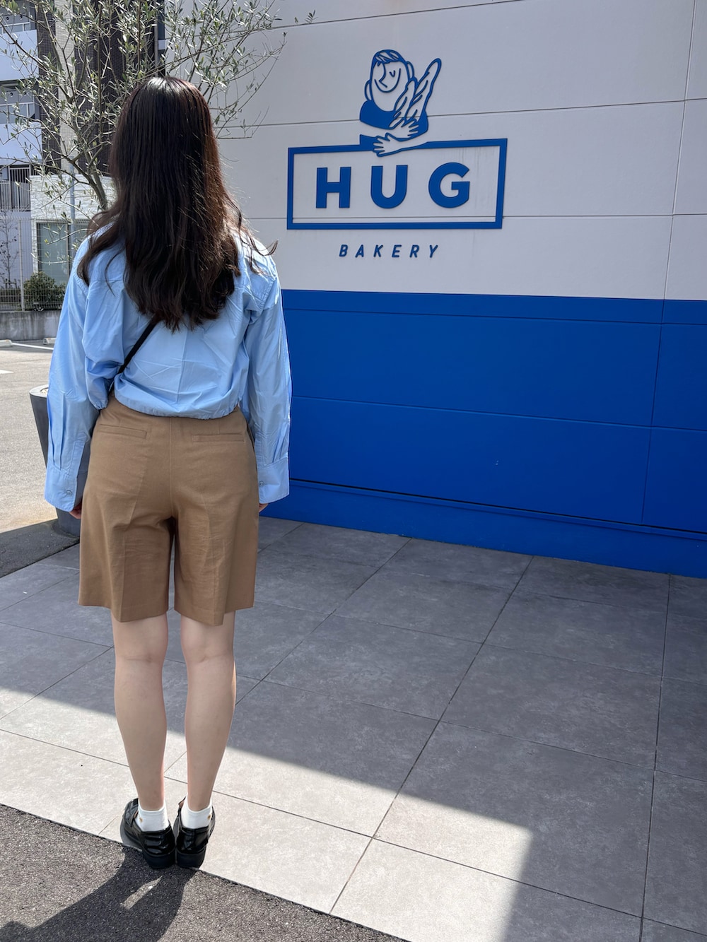 ブルー系のシャツ/ブラウス、ブラウン系のその他パンツ、ブラウン系のショルダーバッグを着用したレディースの春コーディネートの5枚目の写真