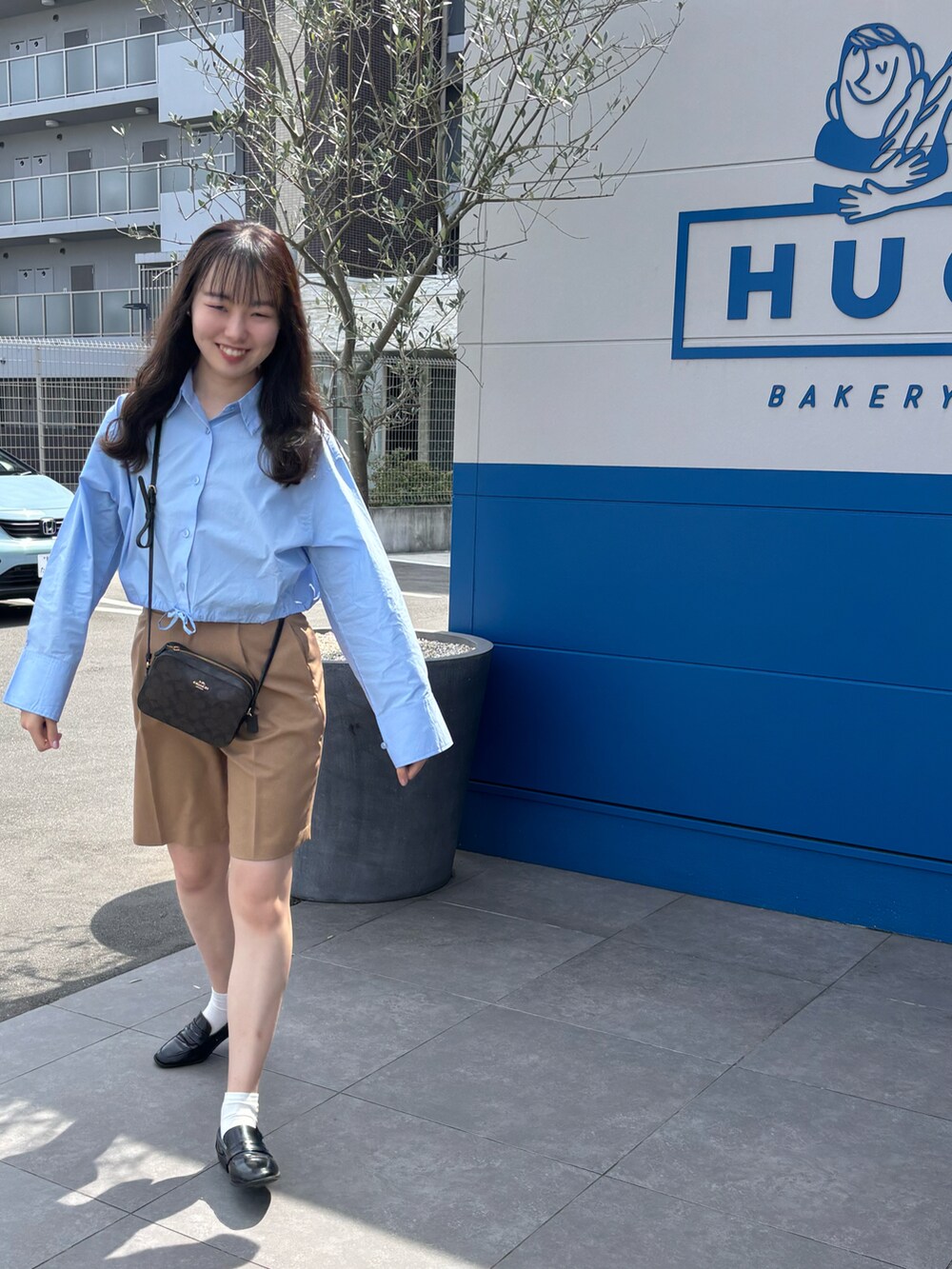 ブルー系のシャツ/ブラウス、ブラウン系のその他パンツ、ブラウン系のショルダーバッグを着用したレディースの春コーディネートの2枚目の写真