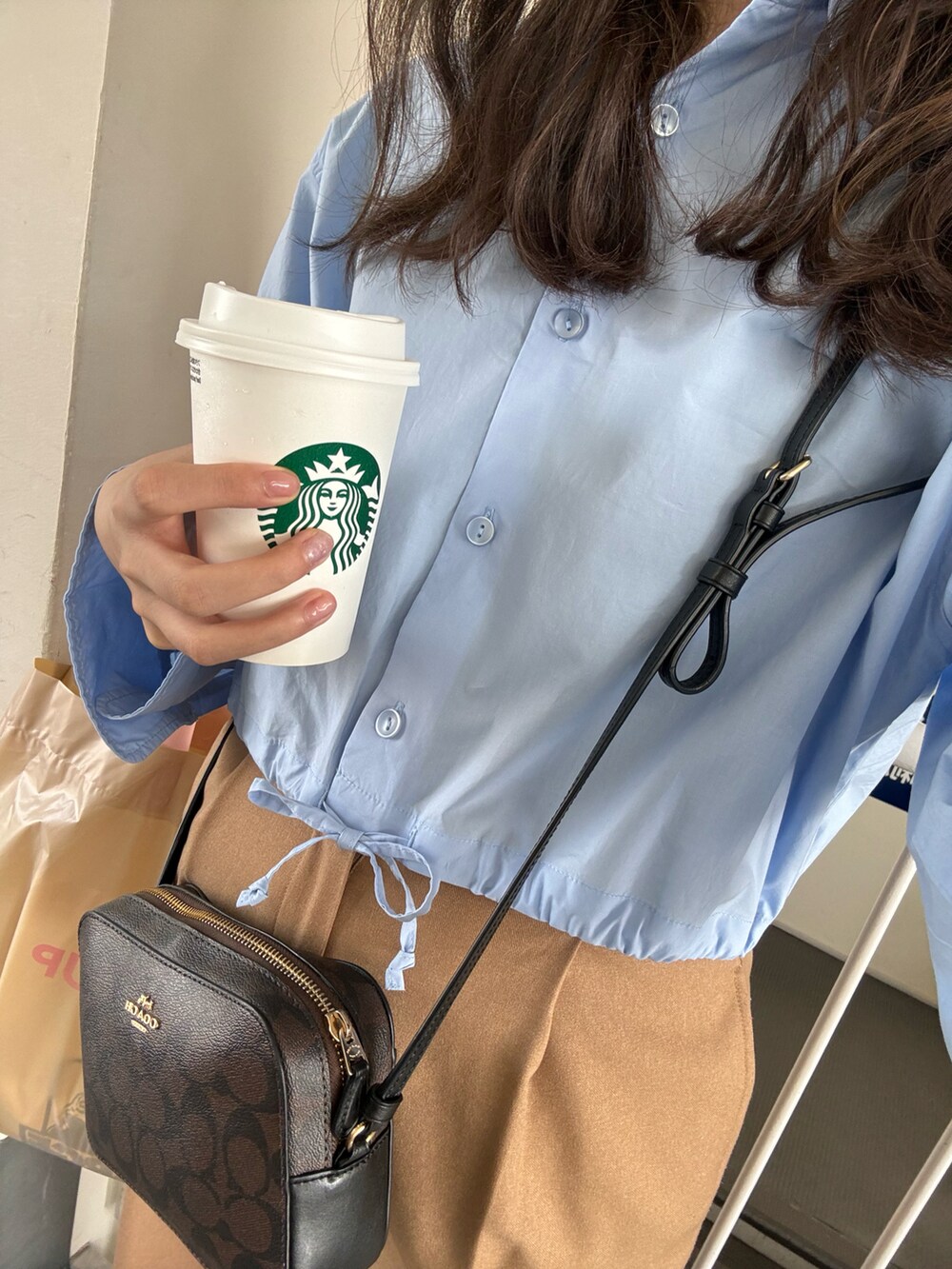 ブルー系のシャツ/ブラウス、ブラウン系のその他パンツ、ブラウン系のショルダーバッグを着用したレディースの春コーディネートの4枚目の写真