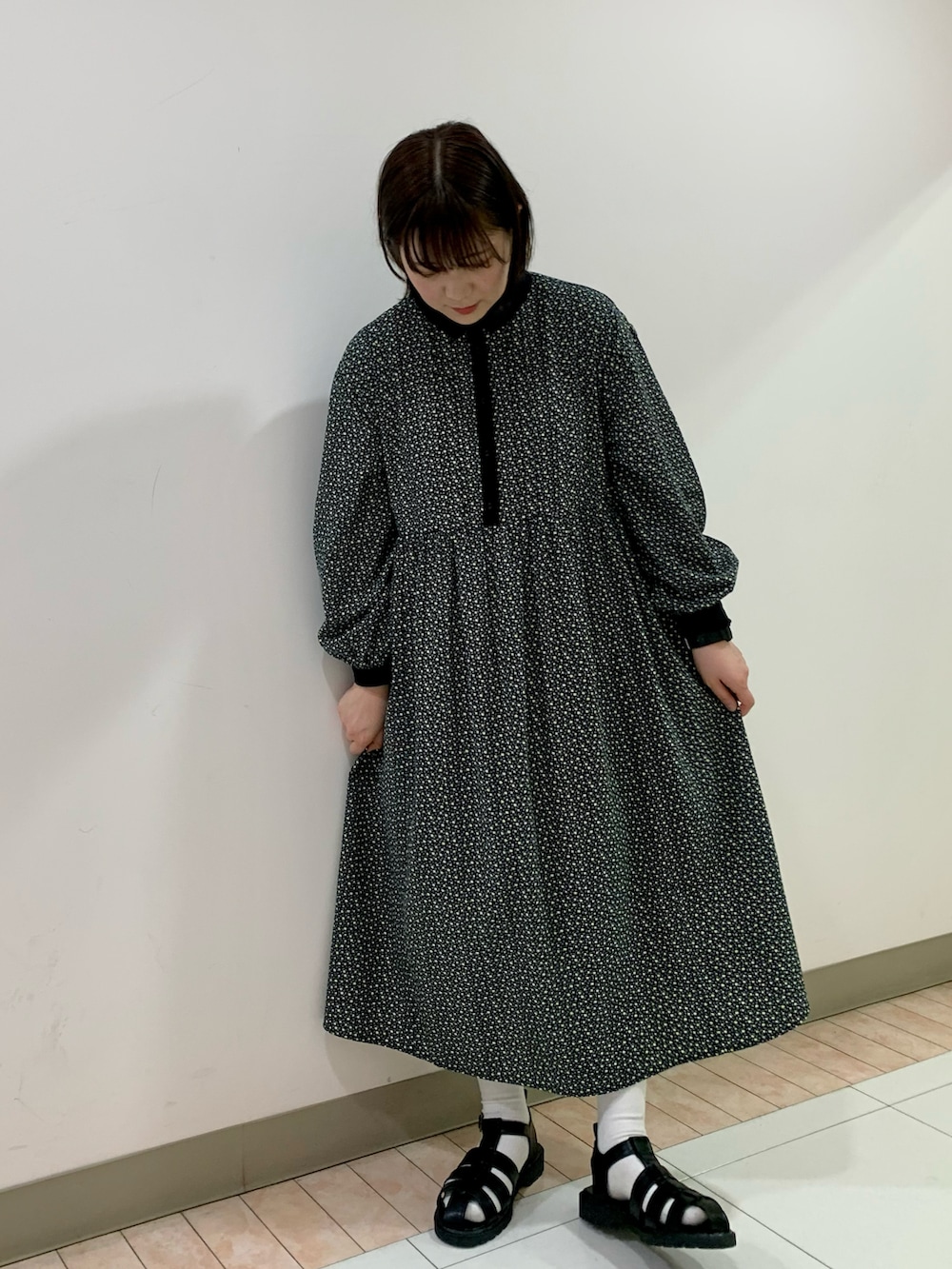 ブラック系のベスト、ブラック系のワンピース、ブラック系のサンダルを着用したレディースの春コーディネートの2枚目の写真