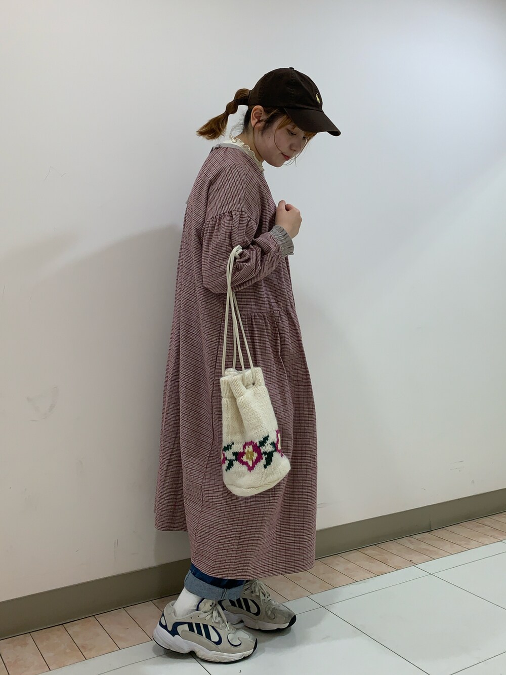 レッド系のワンピース、ホワイト系のハンドバッグを着用したレディースの冬コーディネートの2枚目の写真