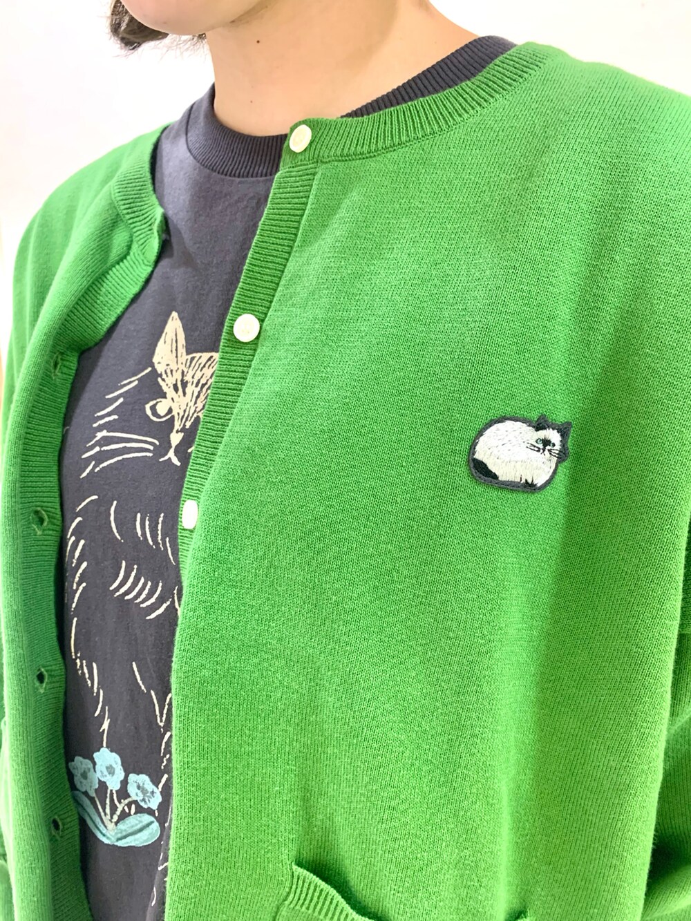 グレー系のTシャツ/カットソー、ブラック系のサンダル、グリーン系のカーディガン/ボレロを着用したレディースの春コーディネートの2枚目の写真