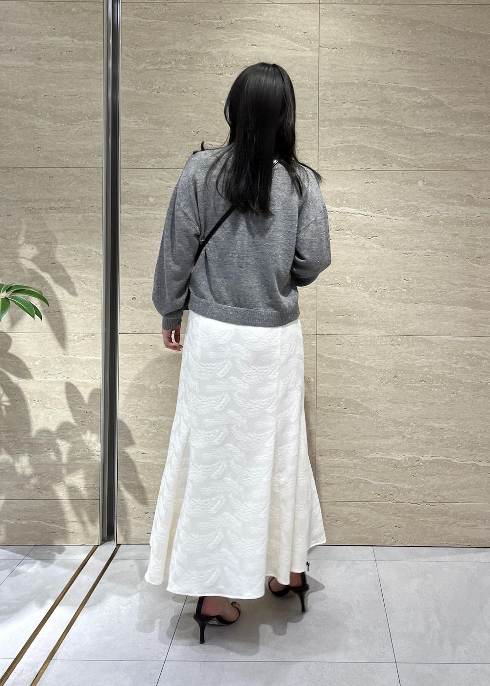 グレー系のカーディガン/ボレロ、ブラック系のサンダル、ホワイト系のスカートを着用したレディースの春コーディネートの3枚目の写真